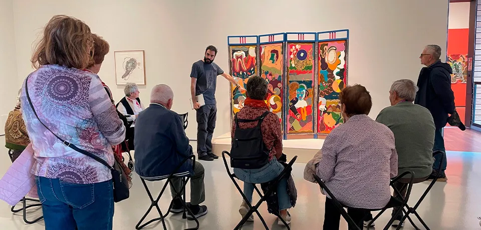 grupo de personas escuchando la explicación sobre una obra de arte