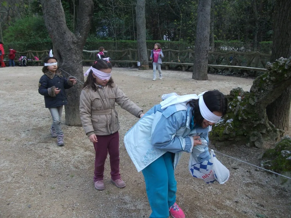Niños haciendo un sendero ciego, agarrados de una cuerda y con los ojos tapados.
