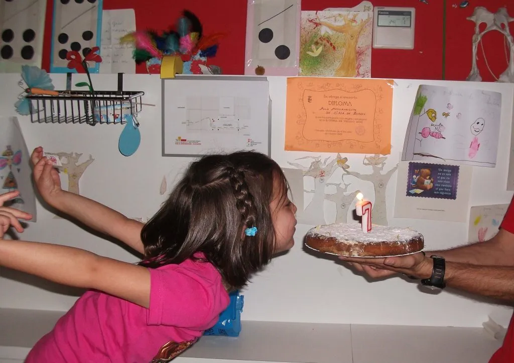Niña soplando una vela